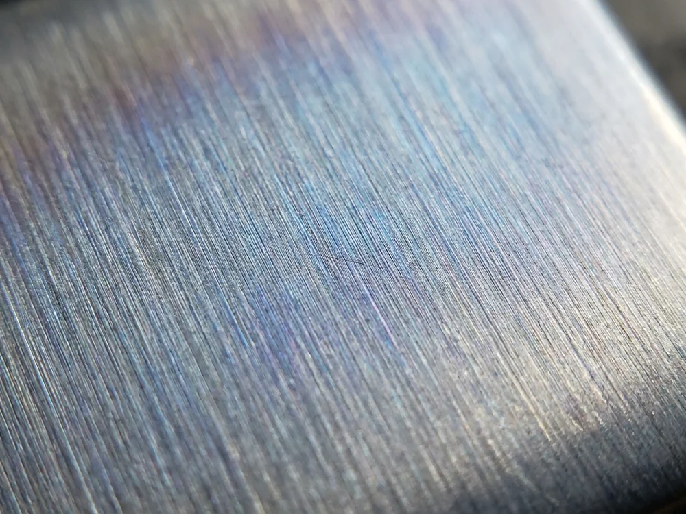 Brushed titanium surface with blue and violet heat tint