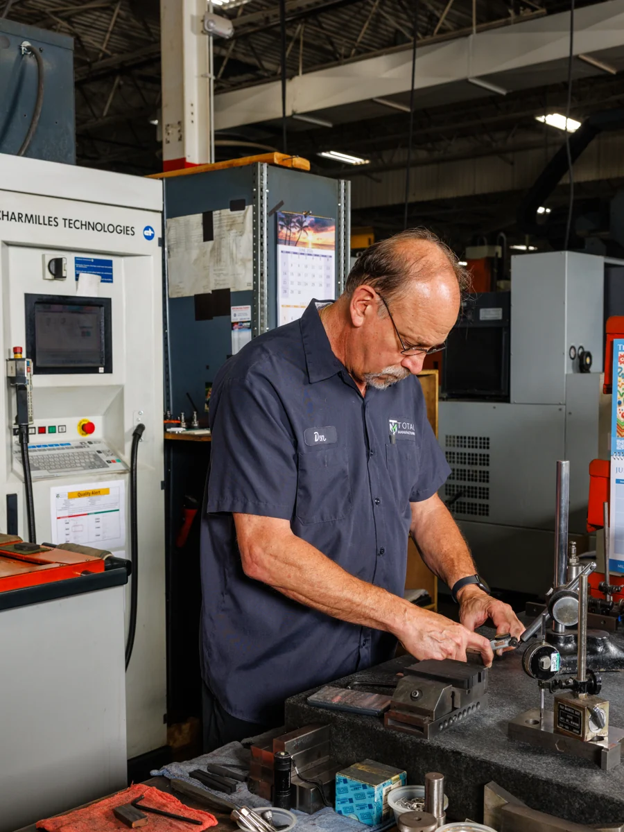 Machinist setting up a fixture at a Charmilles EDM