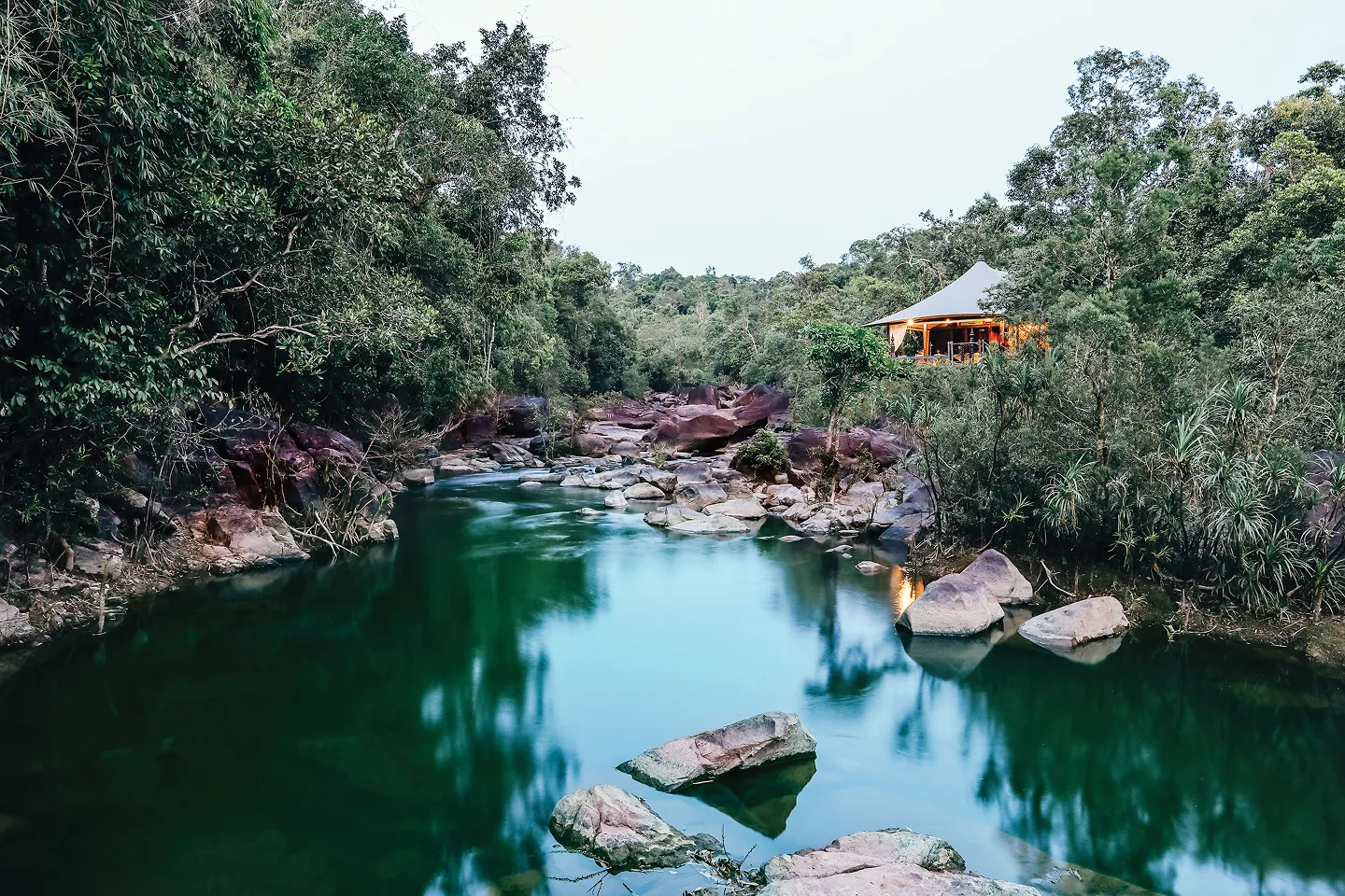 A tent perched above the river in the Cardamom Rainforest