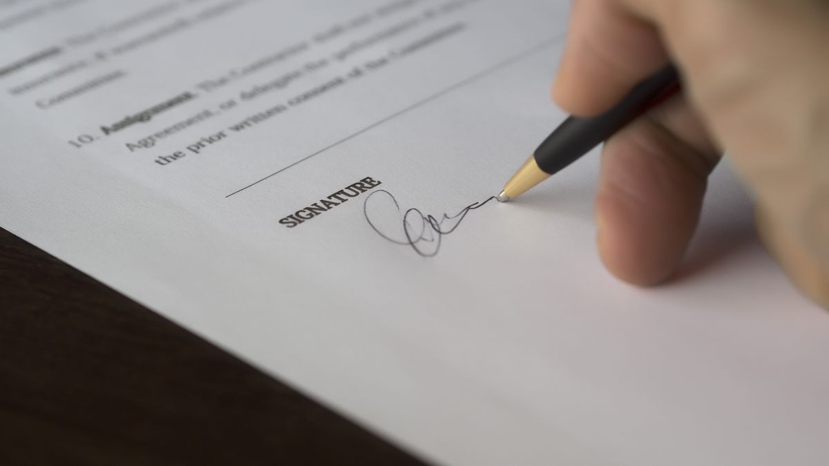 Signing documents at a desk