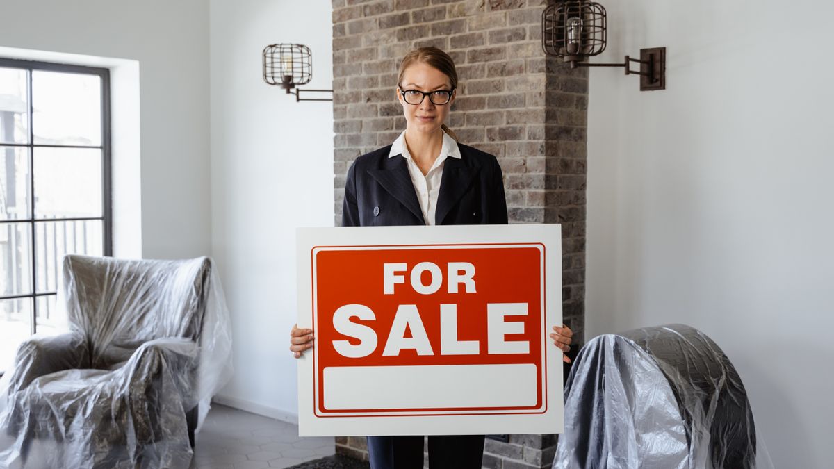 Person holding a For Sale sign
