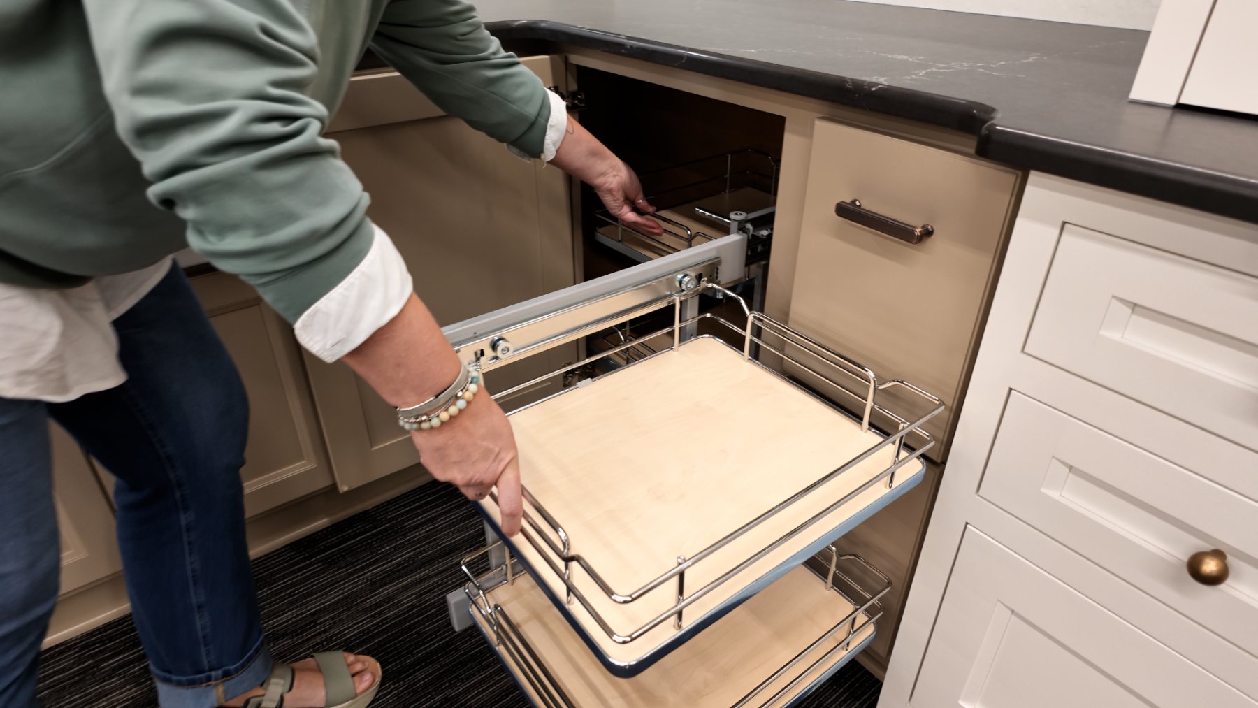 Carly demonstrating a blind corner pull-out with shelves that pull out and slide over