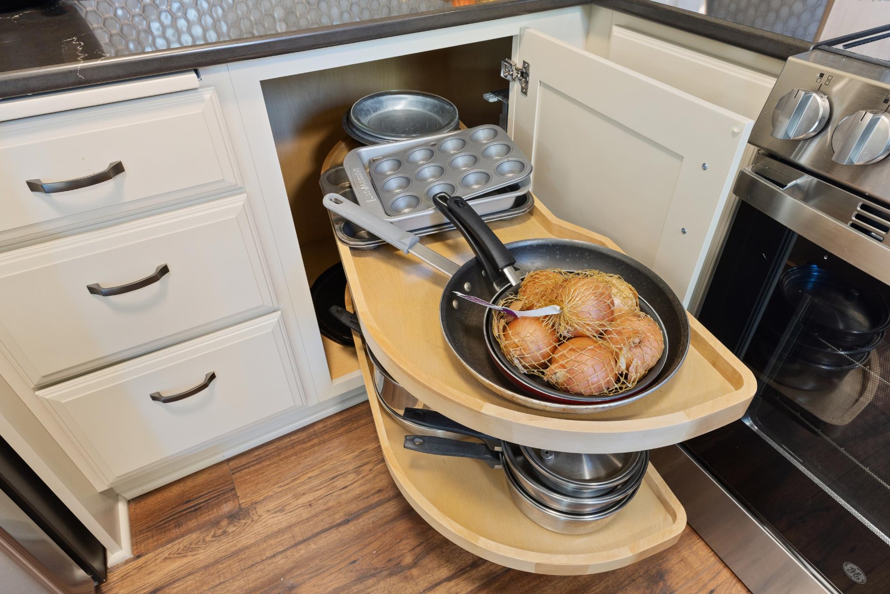 Corner lazy Susan with cookware beside a range in a client kitchen