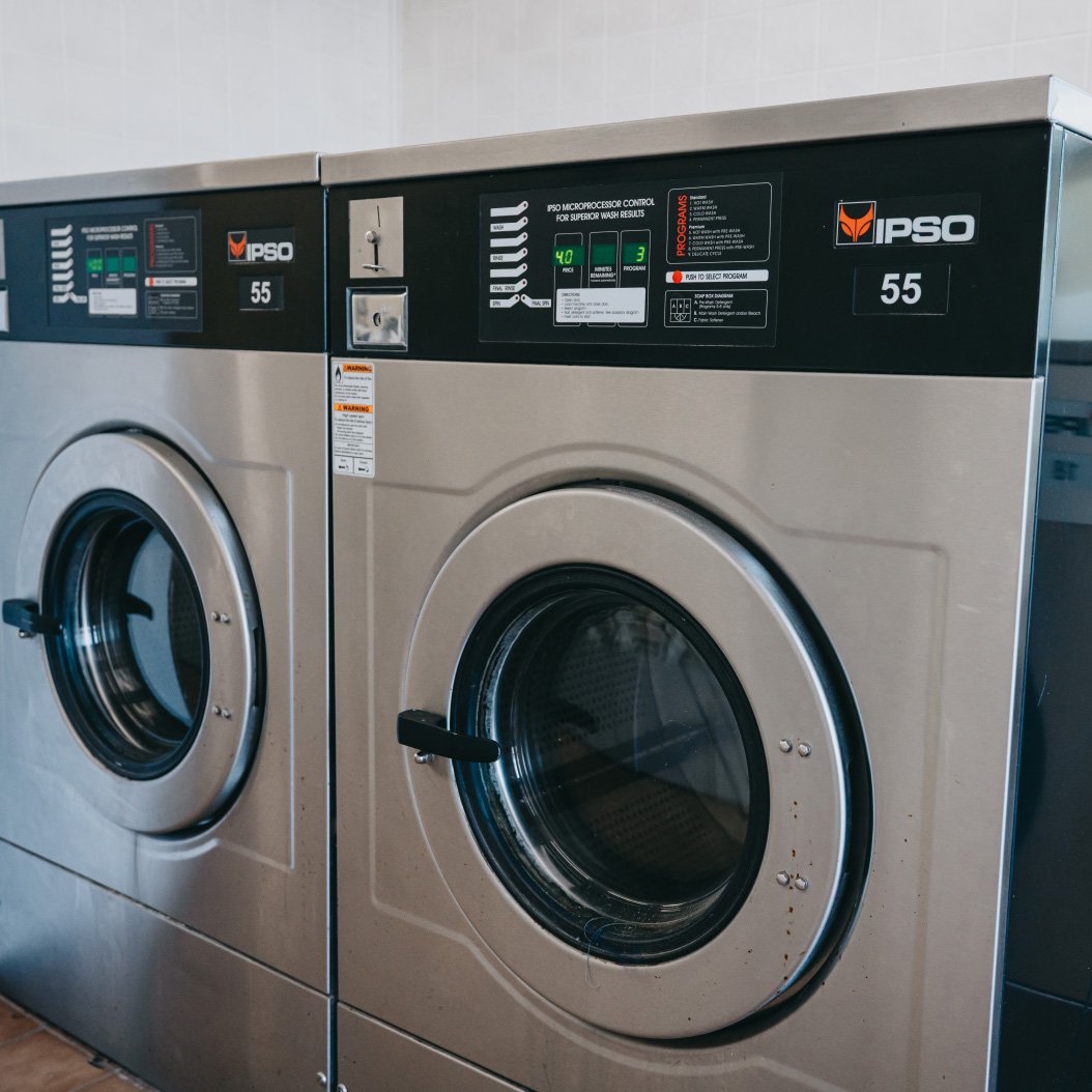 Row of high-efficiency washers inside Legendary Laundromat in Cortland IL