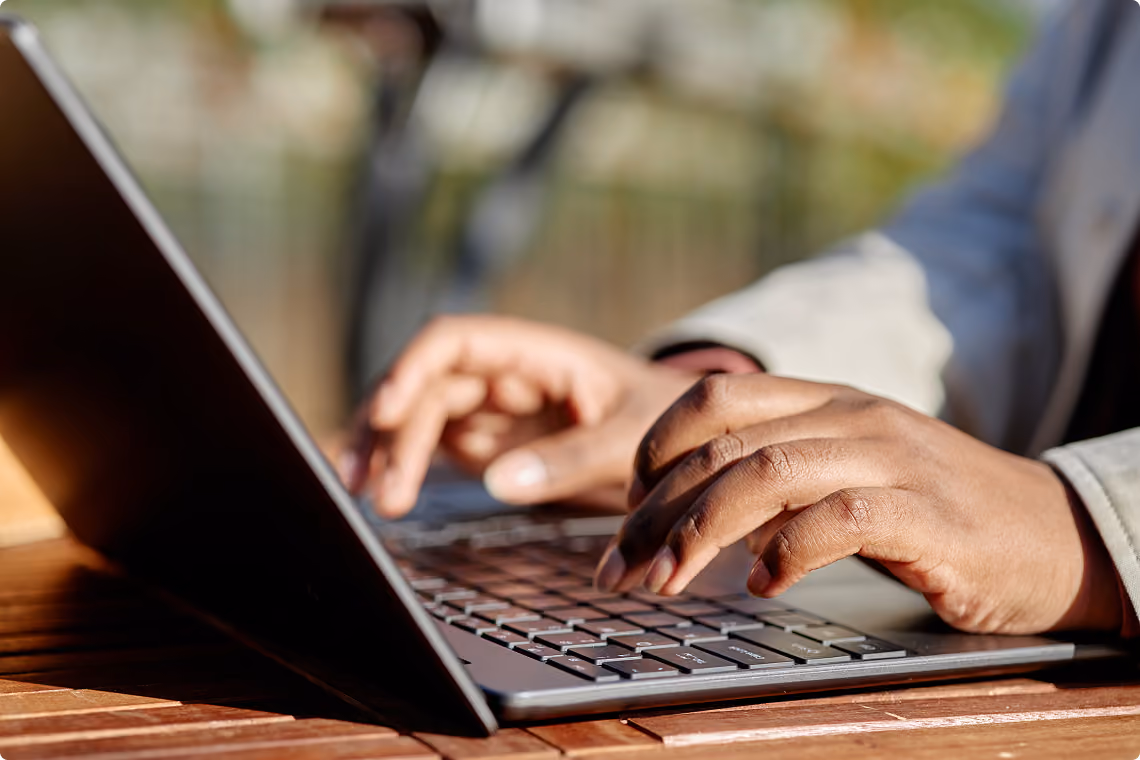 Hands typing on a laptop keyboard