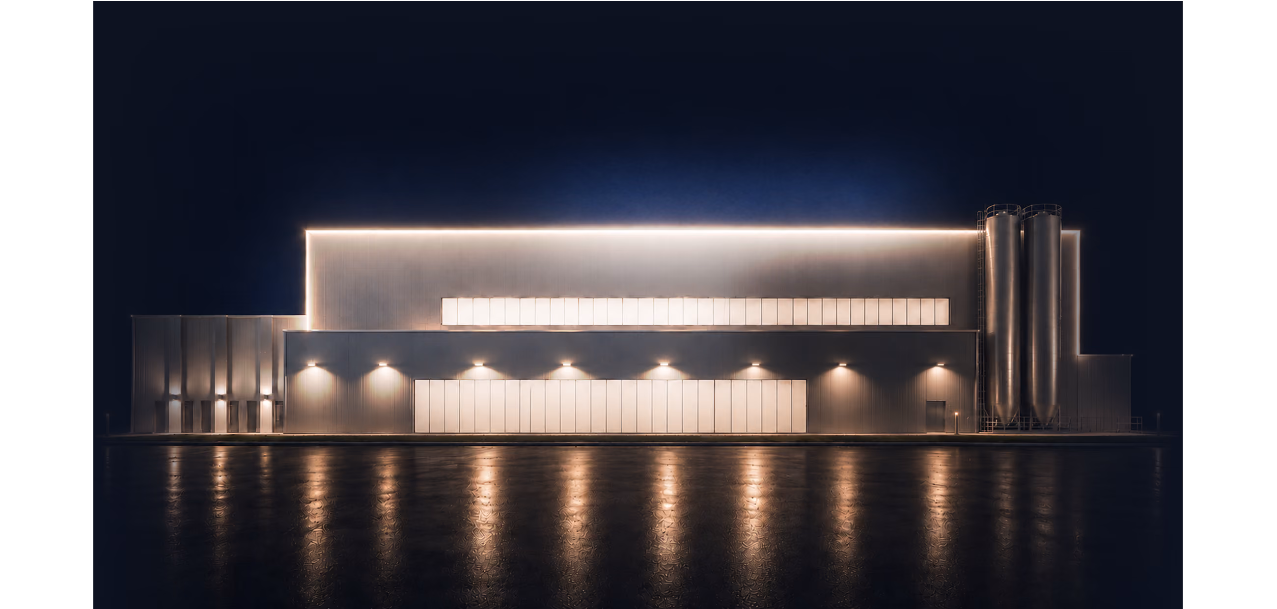 Beleuchtetes Industrie- und Logistikgebäude bei Nacht