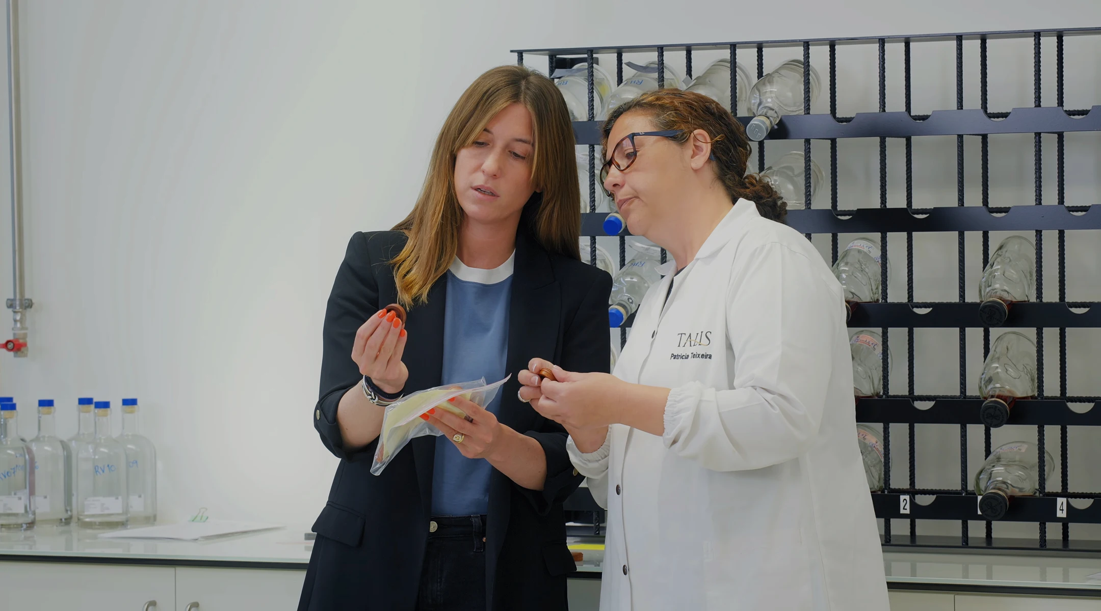 Two women in a laboratory setting examining bartops