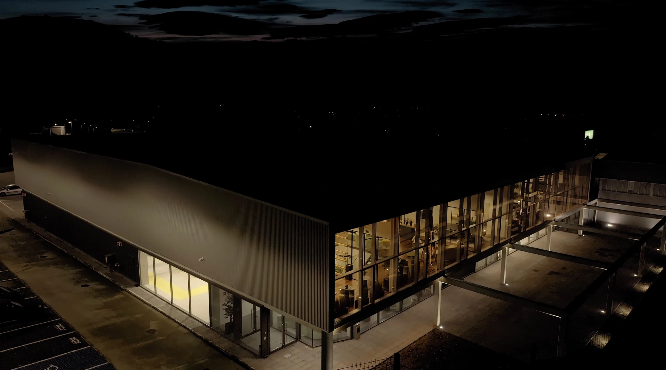 Modern building with large glass windows lit from inside at night