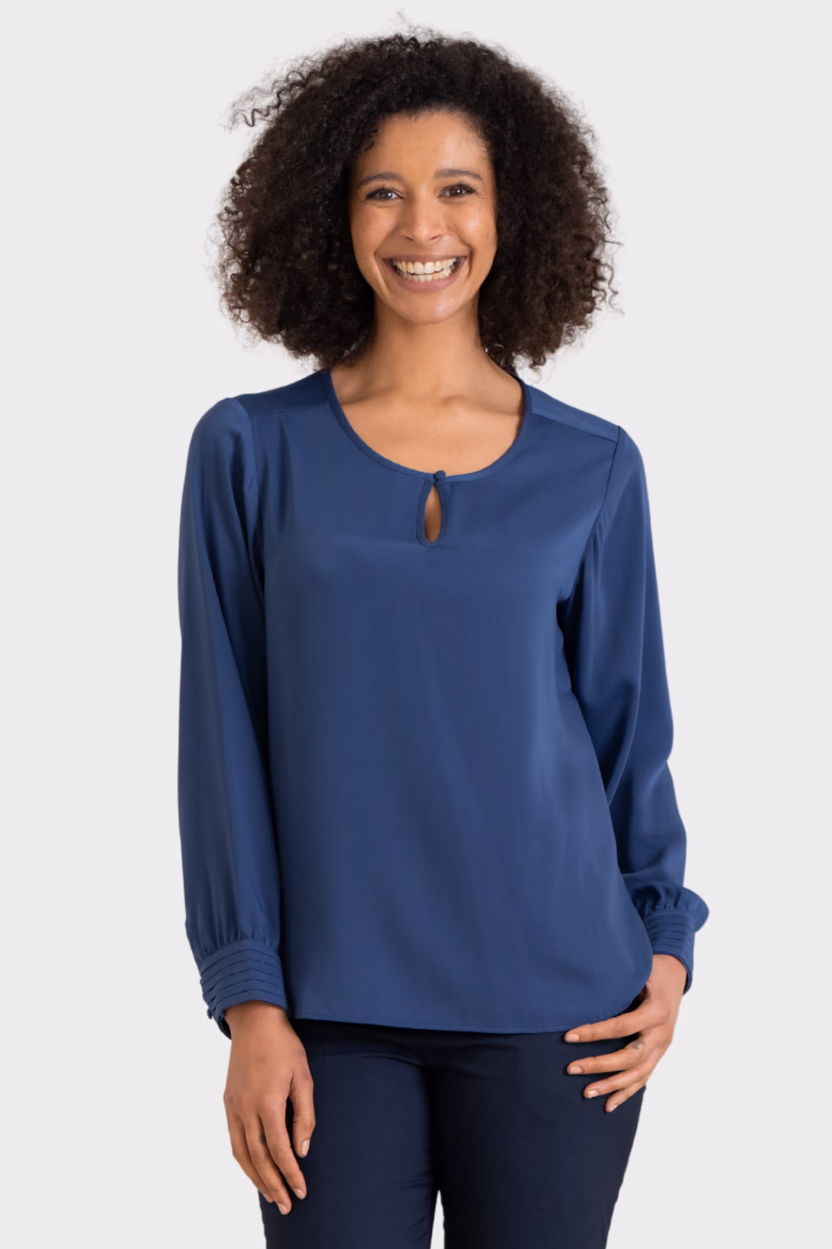 Woman wearing a blue keyhole-neck corporate blouse with navy trousers