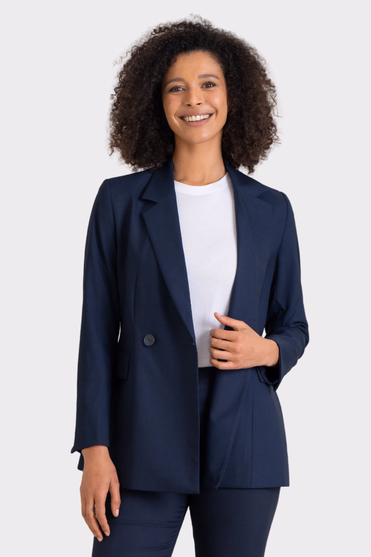 Woman wearing a navy corporate blazer over a white top with matching trousers