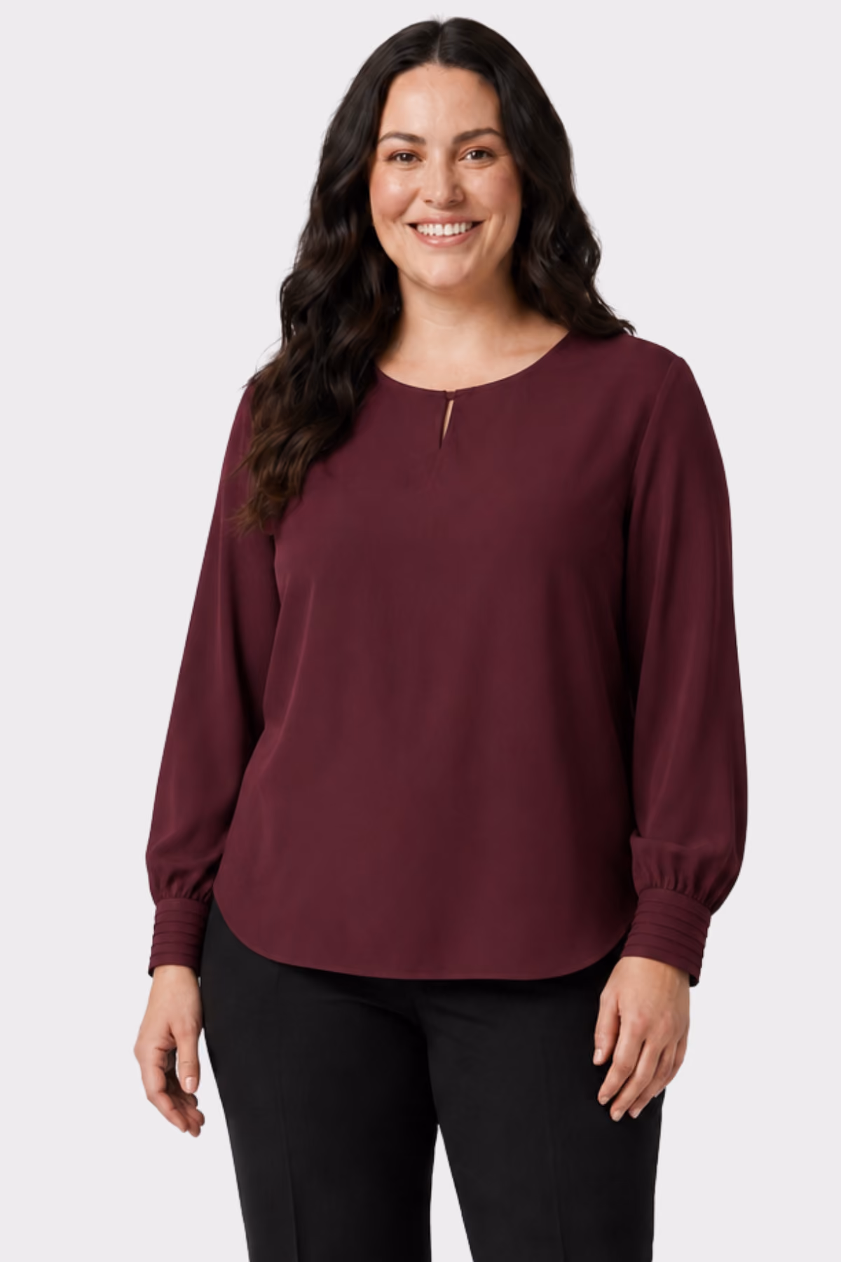 Woman wearing a burgundy long-sleeve hospitality blouse with black trousers