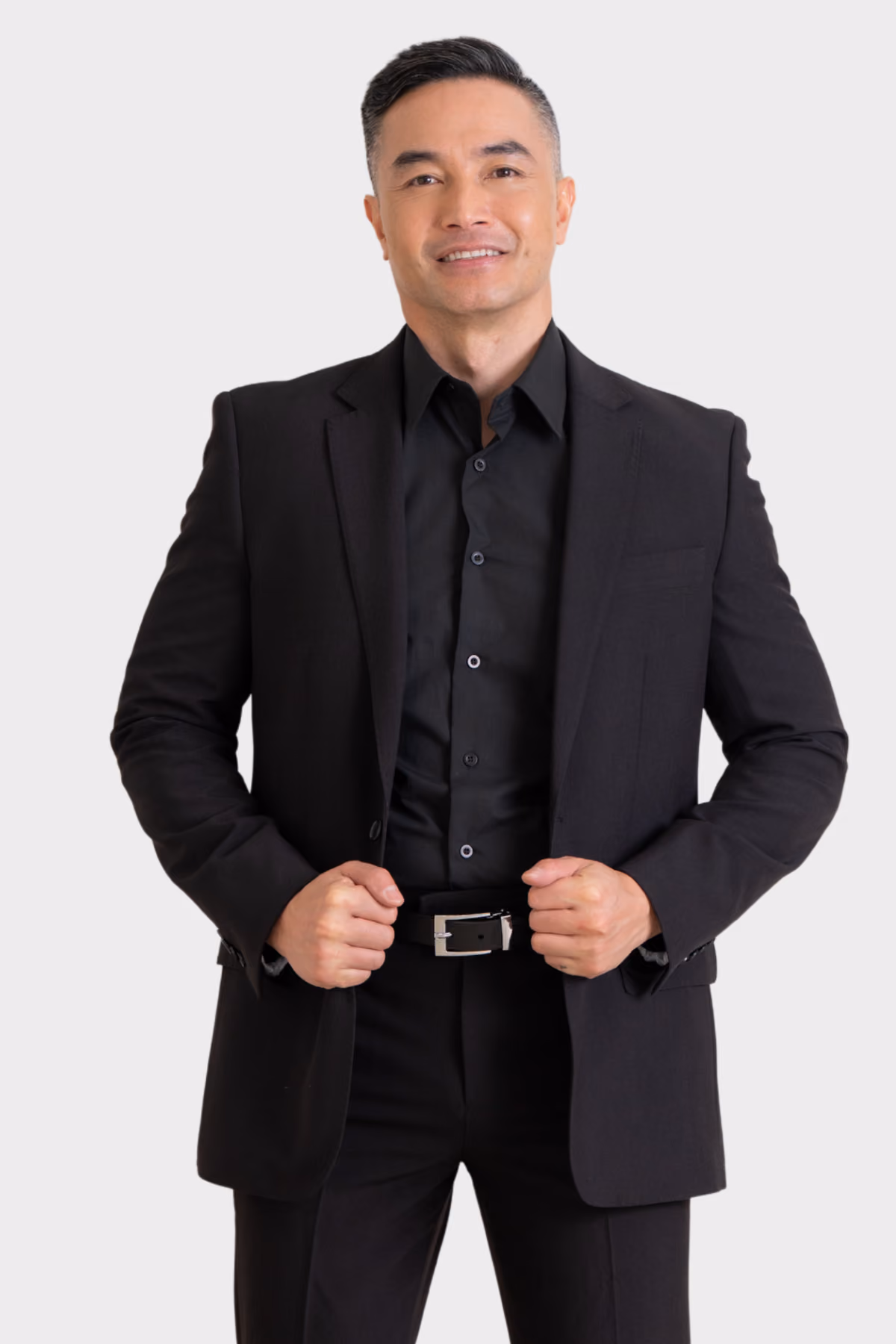 Man wearing an all-black hospitality suit jacket and shirt with black trousers