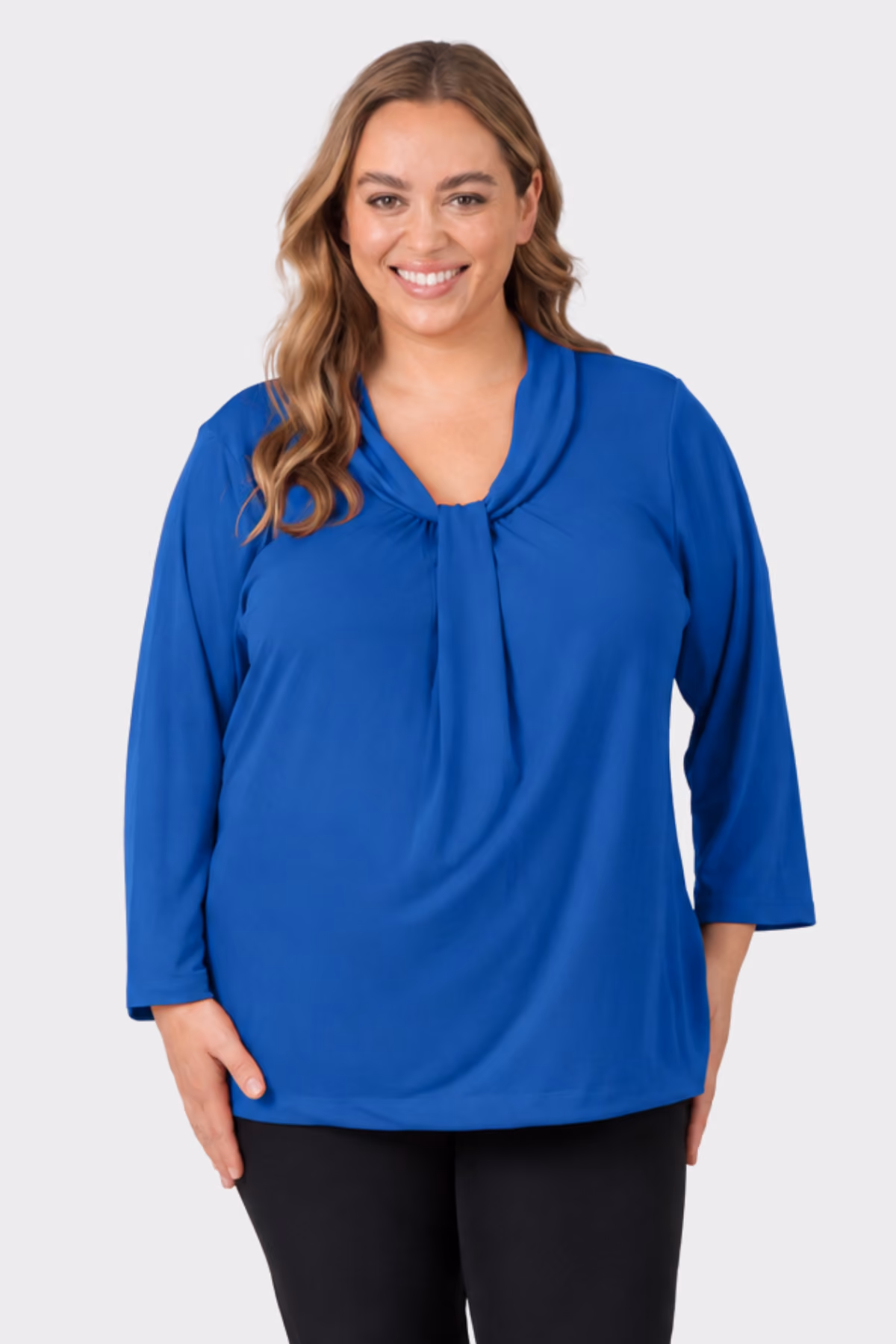 Woman wearing a bright blue three-quarter sleeve healthcare top with black trousers