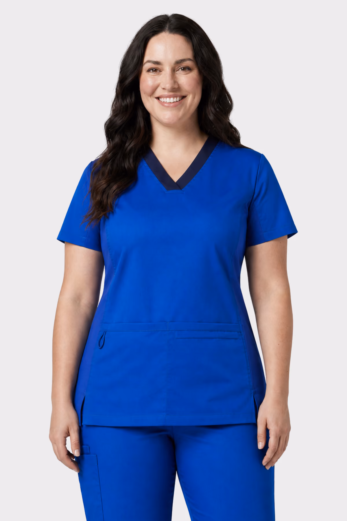 Woman wearing a bright blue healthcare scrub top with navy trim and matching trousers