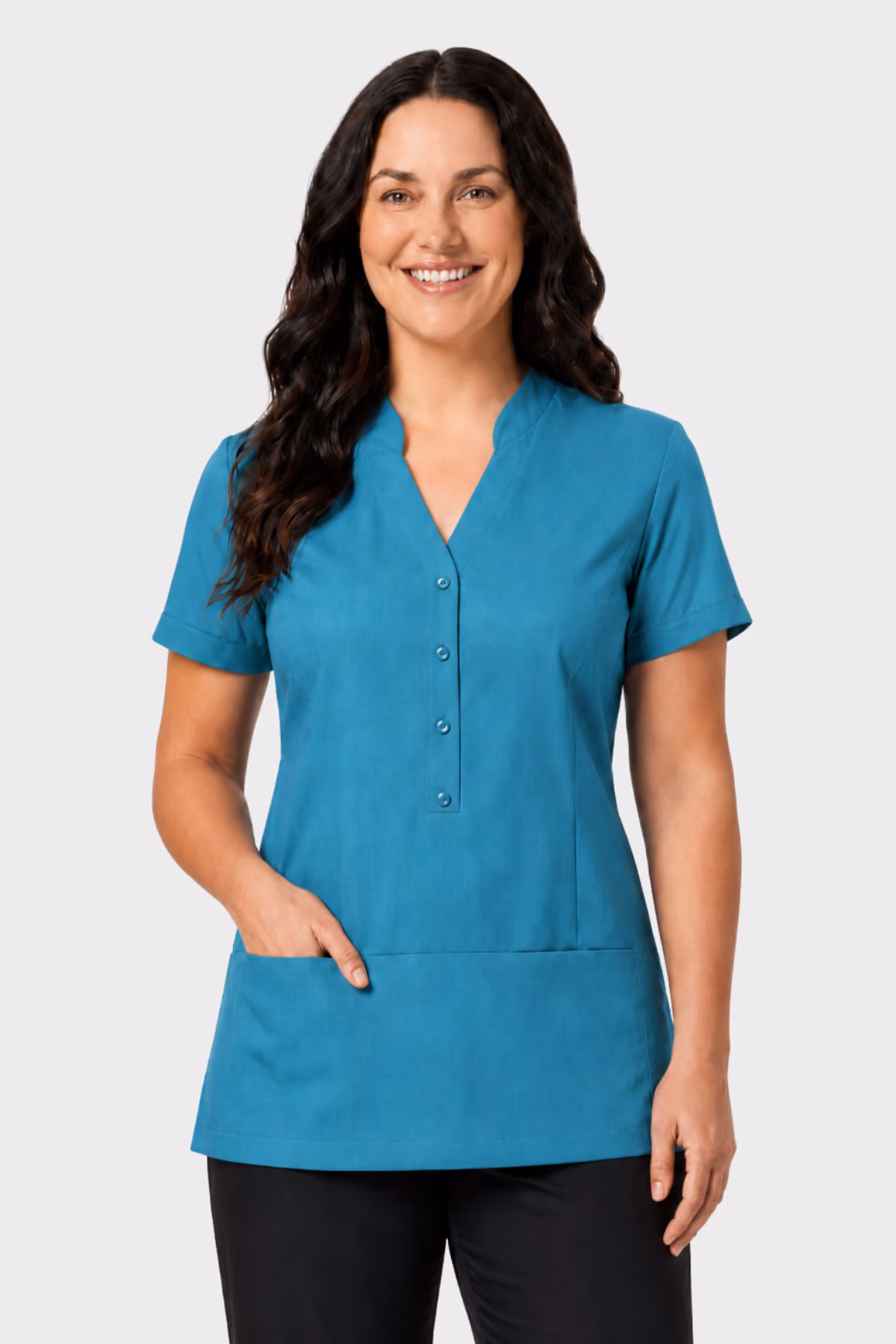 Woman wearing a teal aged care tunic with front pockets and black trousers