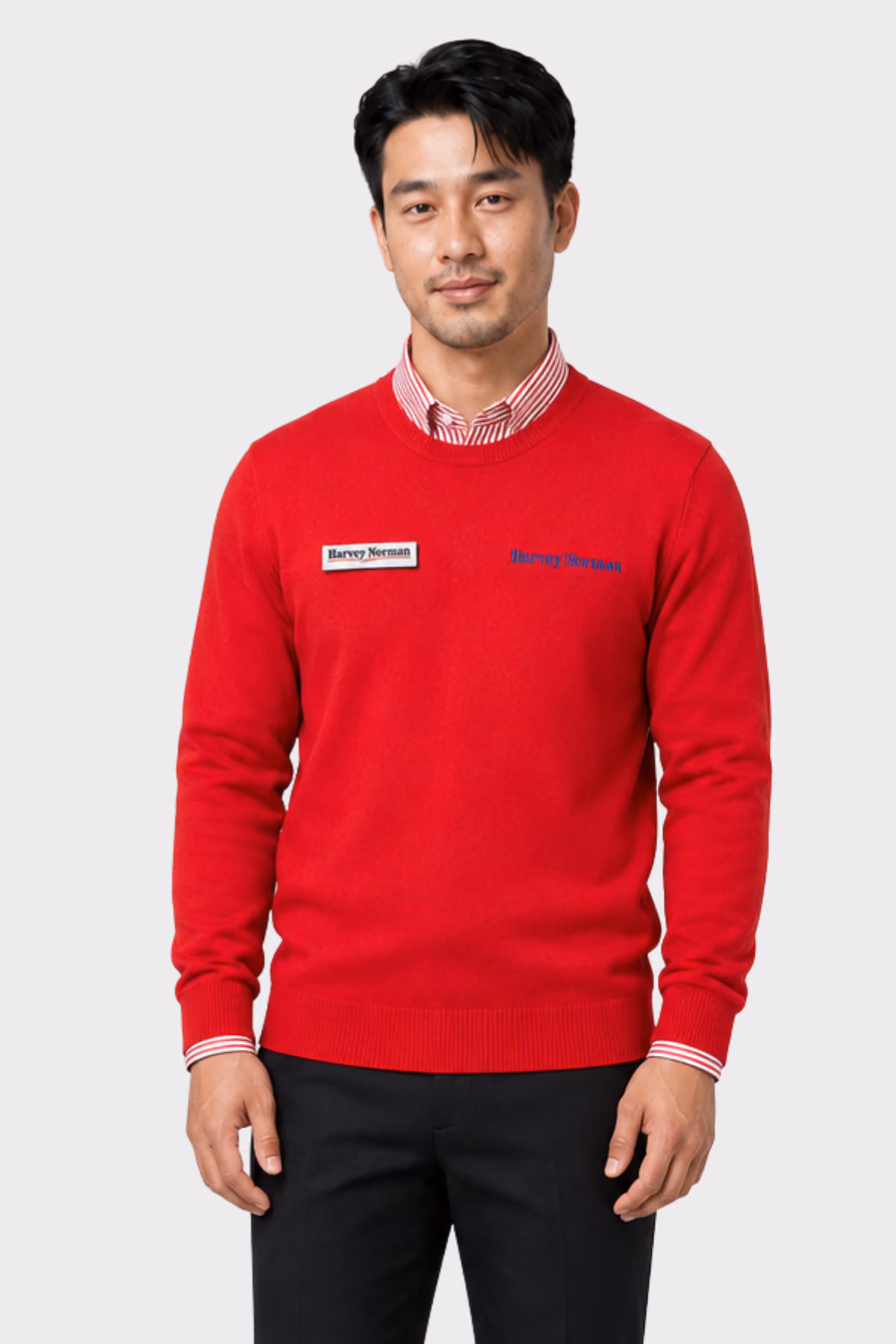 Man wearing a red branded retail jumper over a striped collared shirt