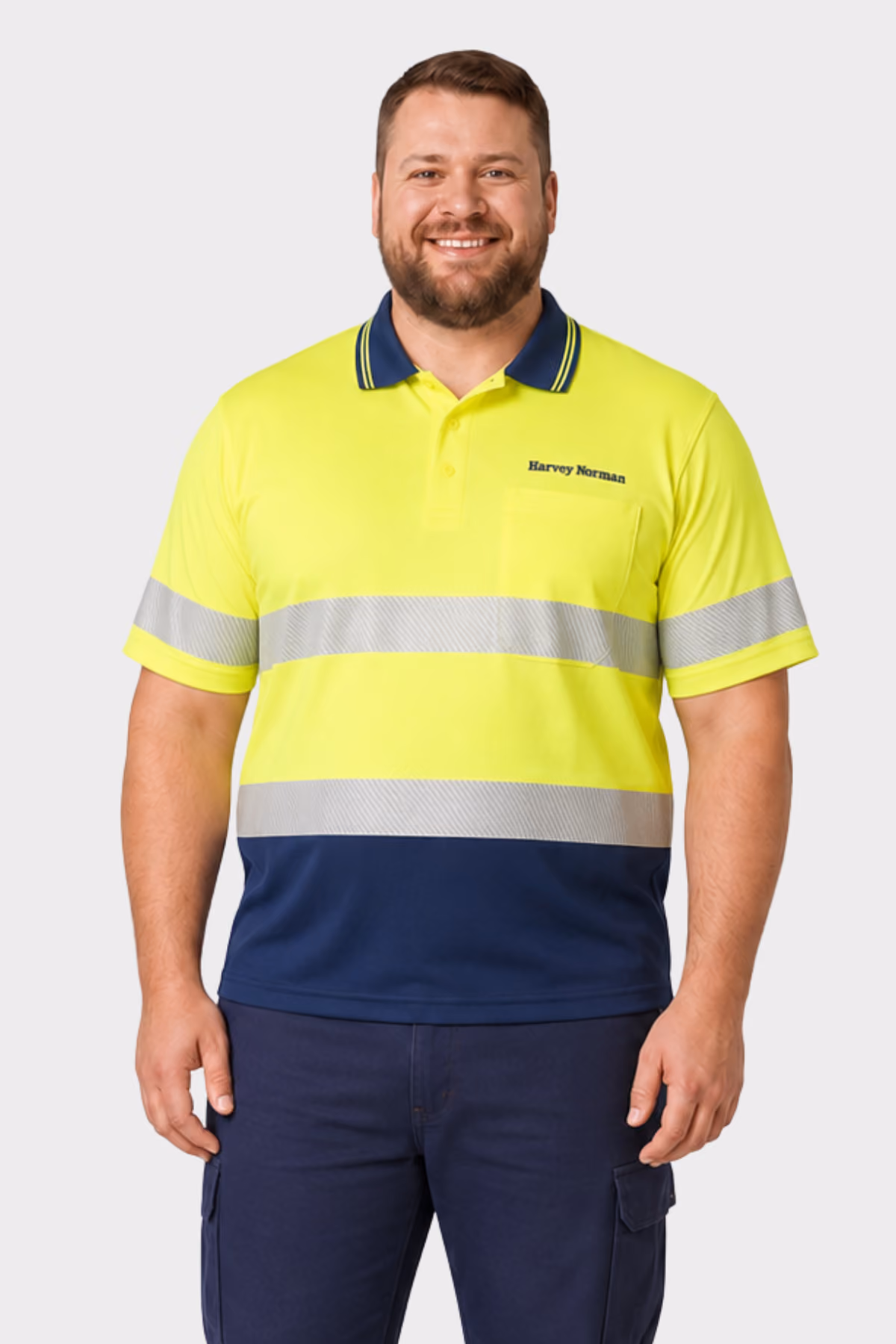 Man wearing a yellow and navy hi-vis polo with reflective tape and navy cargo trousers