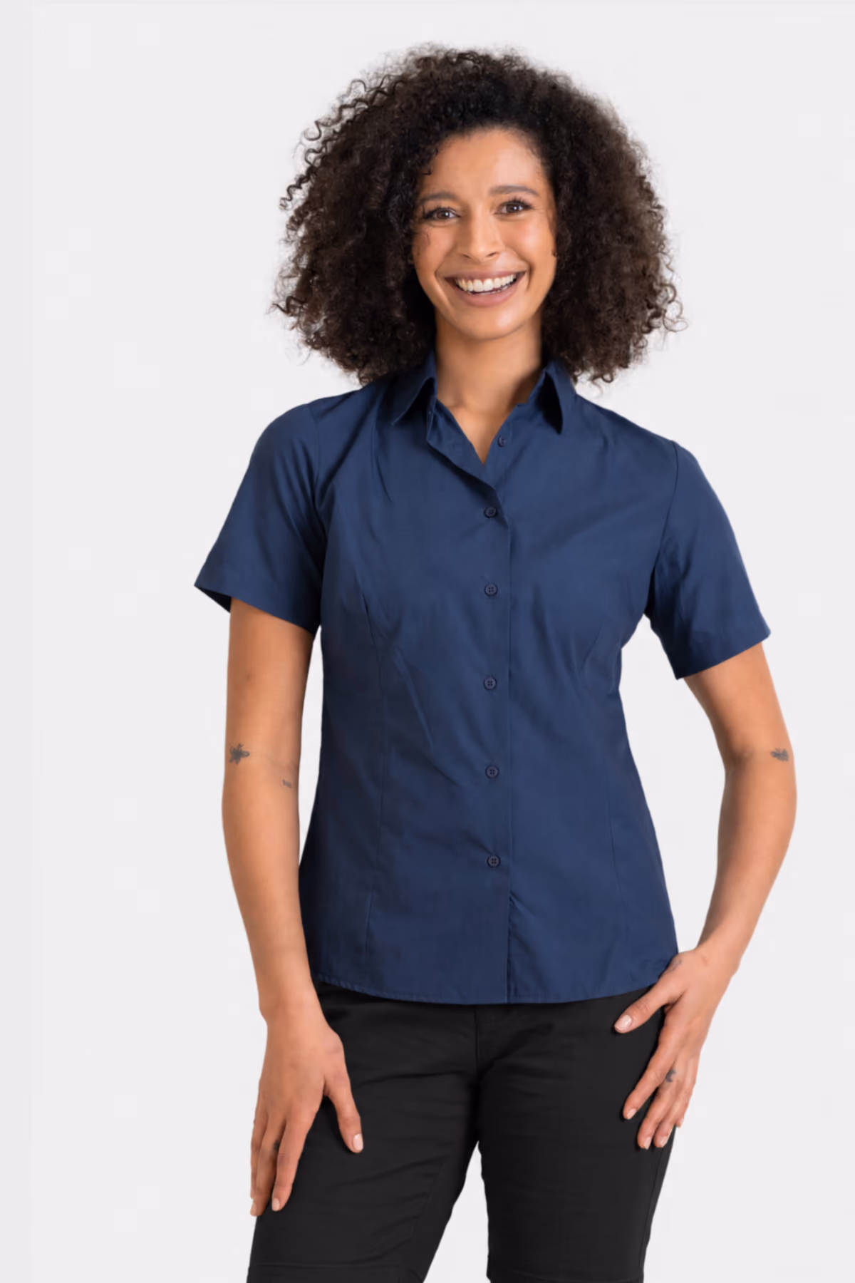 Woman wearing a navy short-sleeve education shirt with black trousers