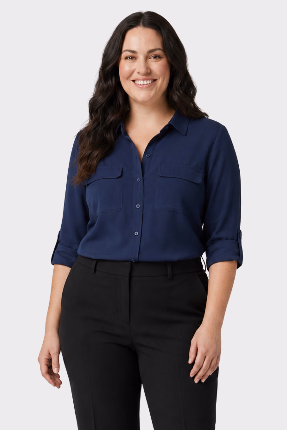 Woman wearing a navy roll-sleeve blouse with chest pockets and black trousers