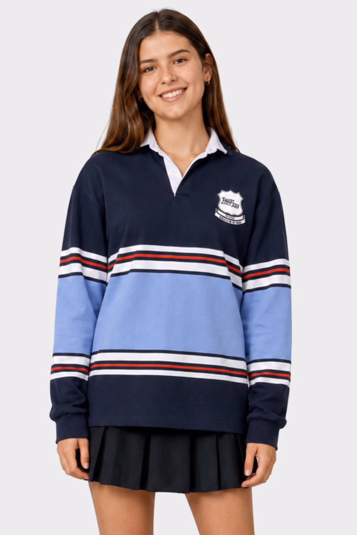 Student wearing a navy and light blue striped school rugby jersey with a pleated skirt