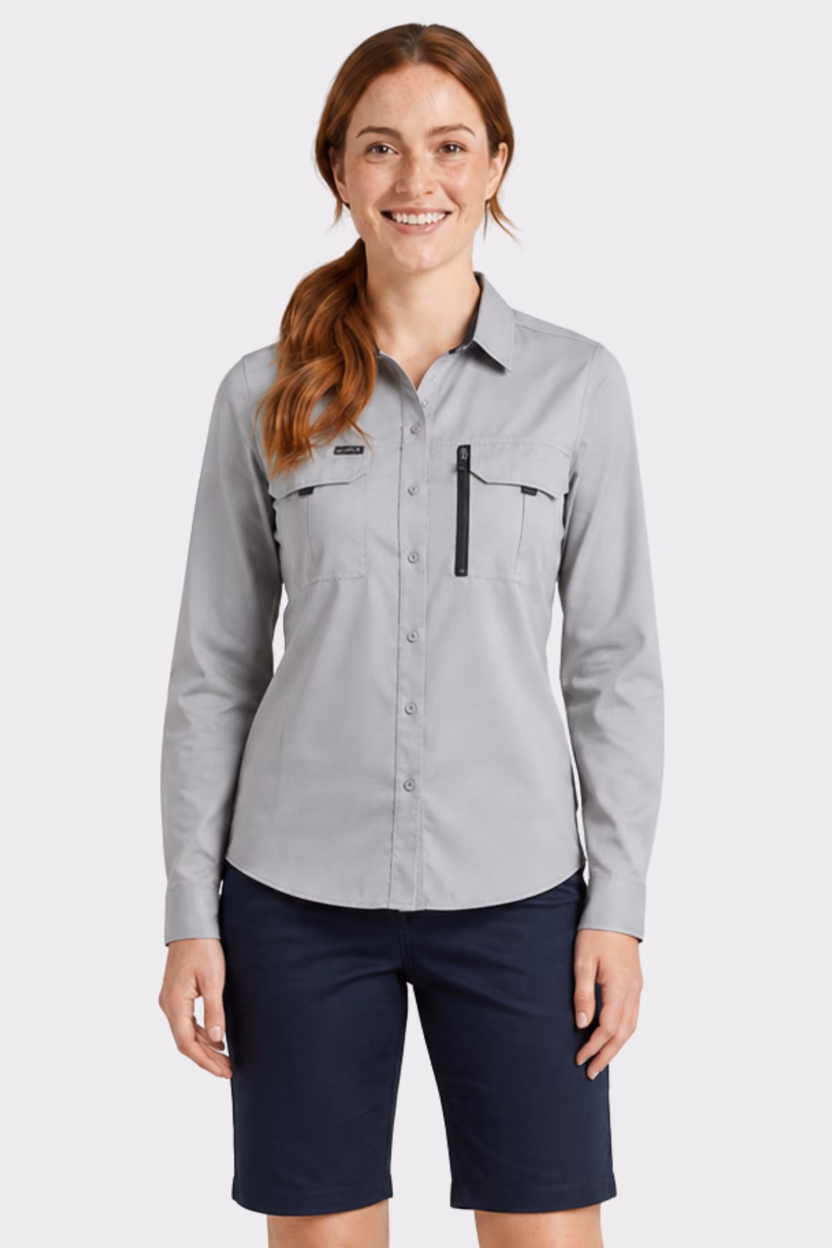 Woman wearing a light grey long-sleeve work shirt with navy shorts
