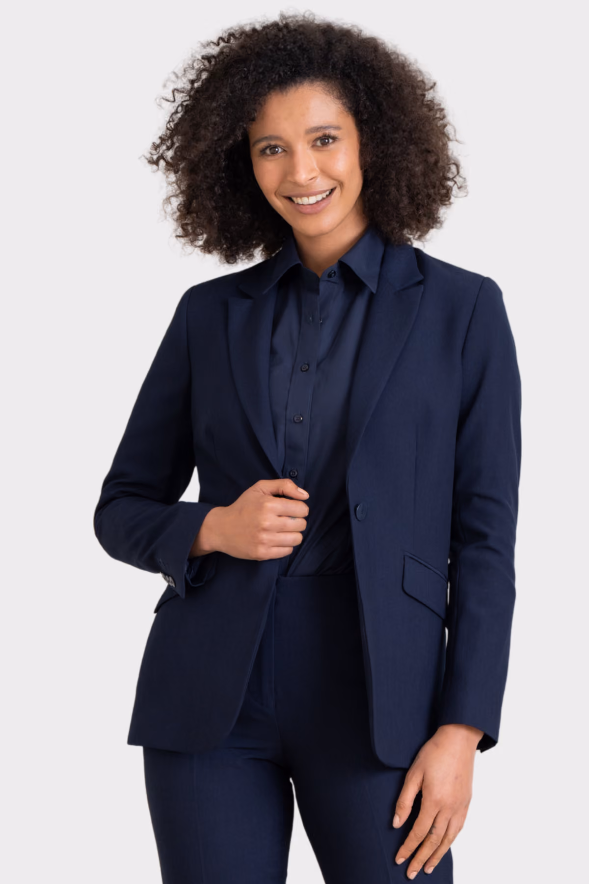 Woman wearing a navy suit blazer over a navy shirt with matching trousers