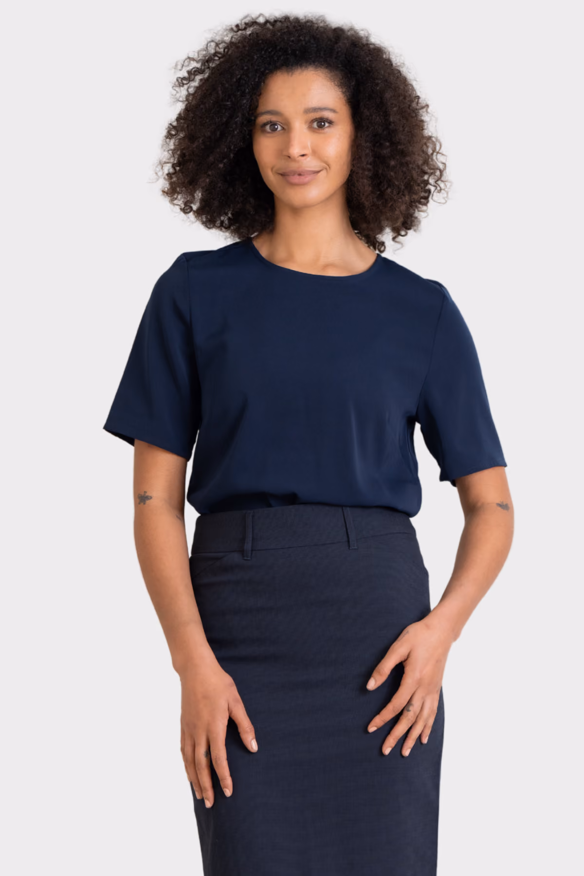 Woman wearing a navy short-sleeve top with a navy pencil skirt