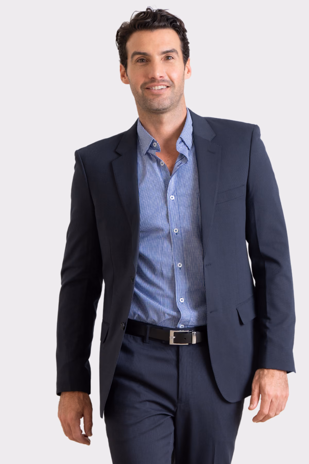 Man wearing a charcoal suit jacket over a blue shirt with navy trousers