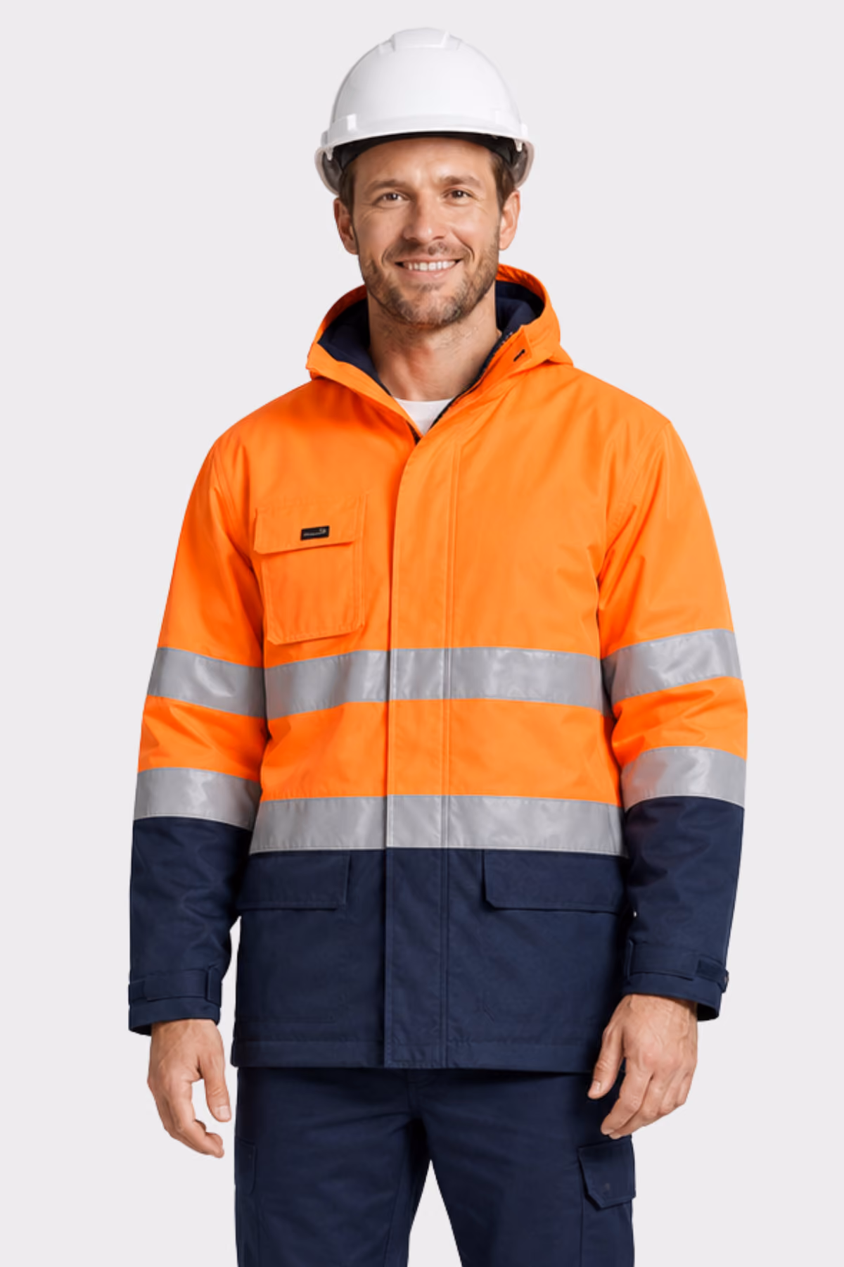 Man wearing an orange and navy hi-vis jacket with reflective tape and a white hard hat