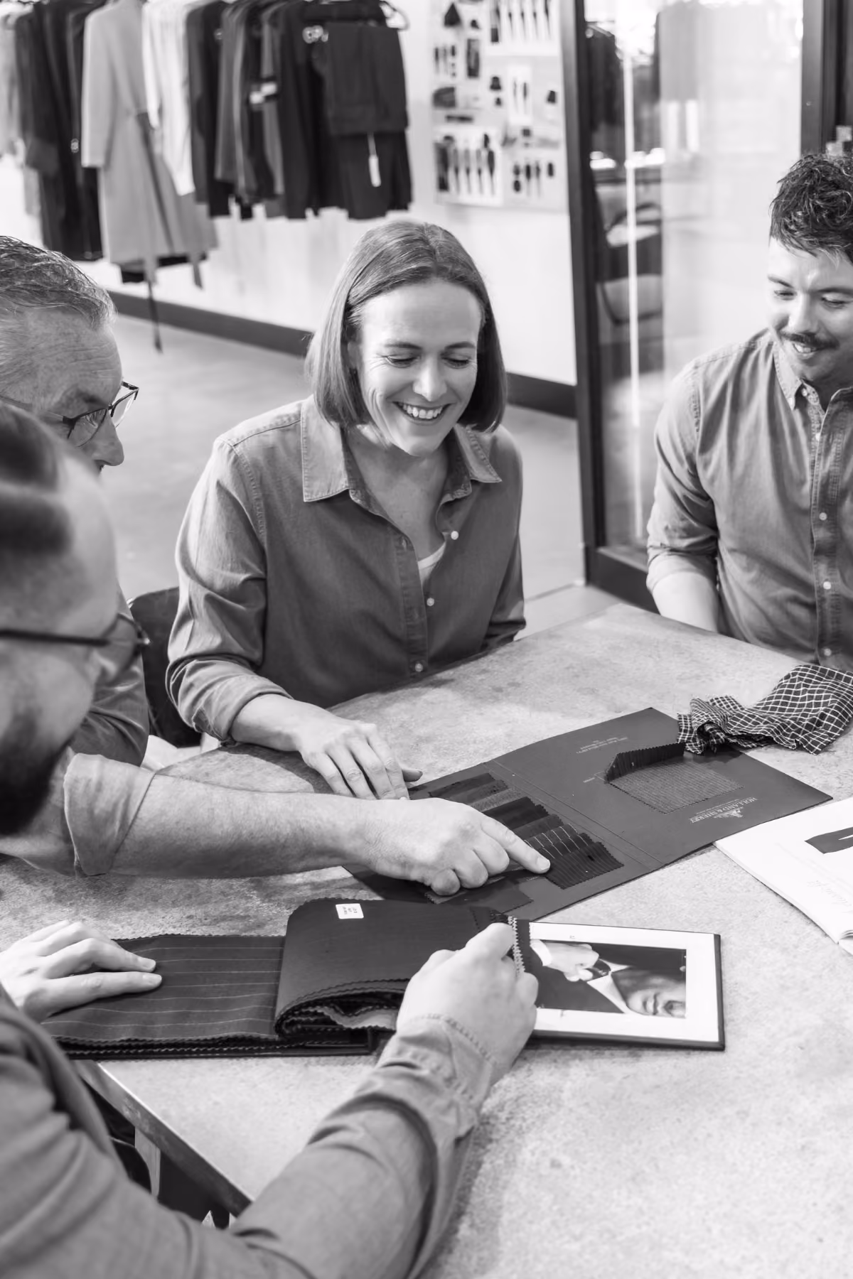 Team reviewing fabric swatches and uniform designs around a table