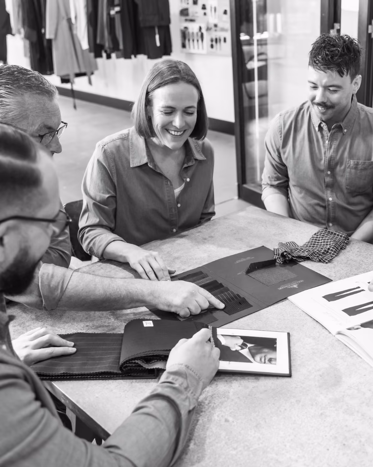 Team reviewing fabric swatches and designs around a table