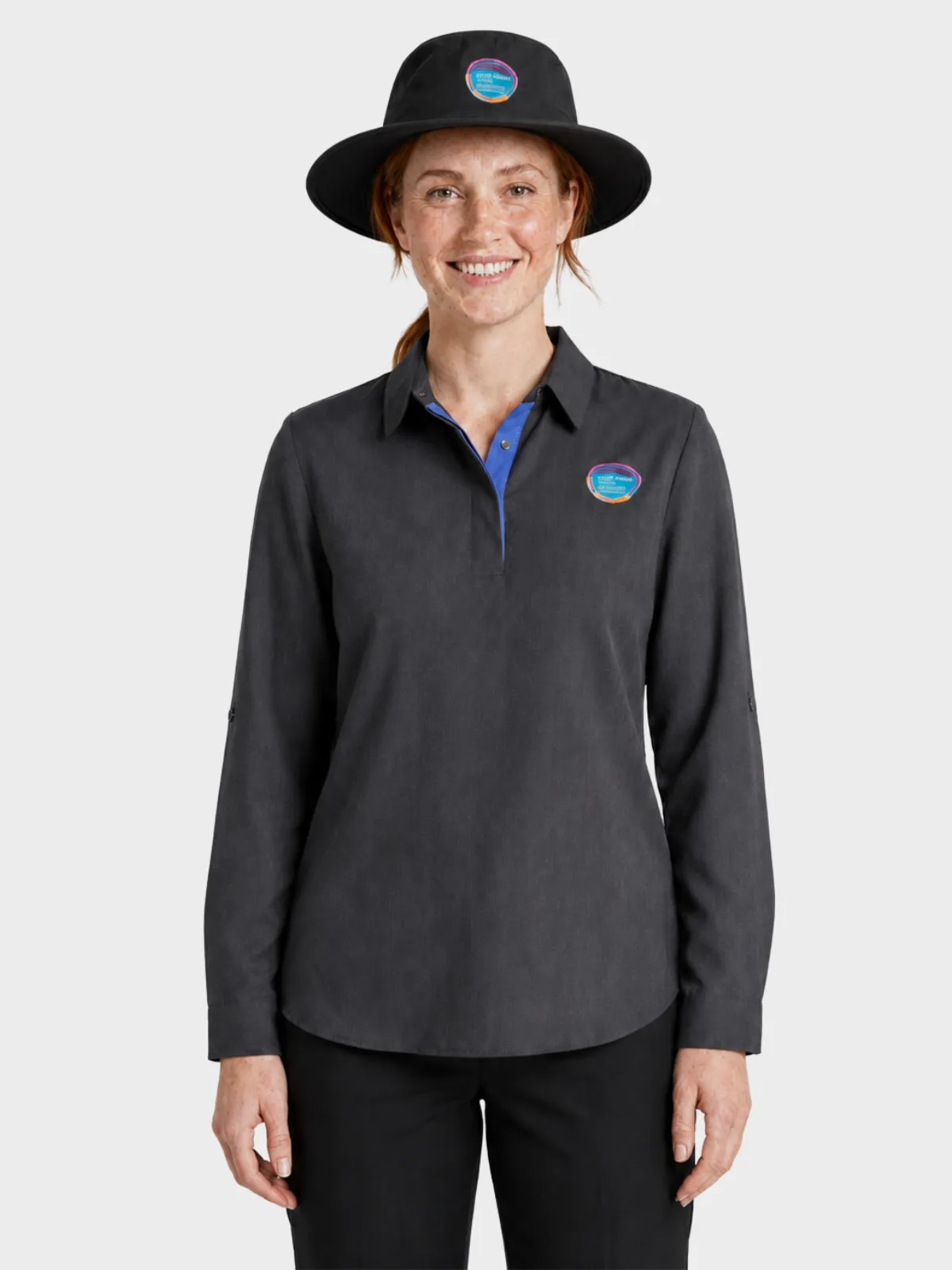 Woman wearing a charcoal long-sleeve education shirt with blue placket and a wide-brim hat