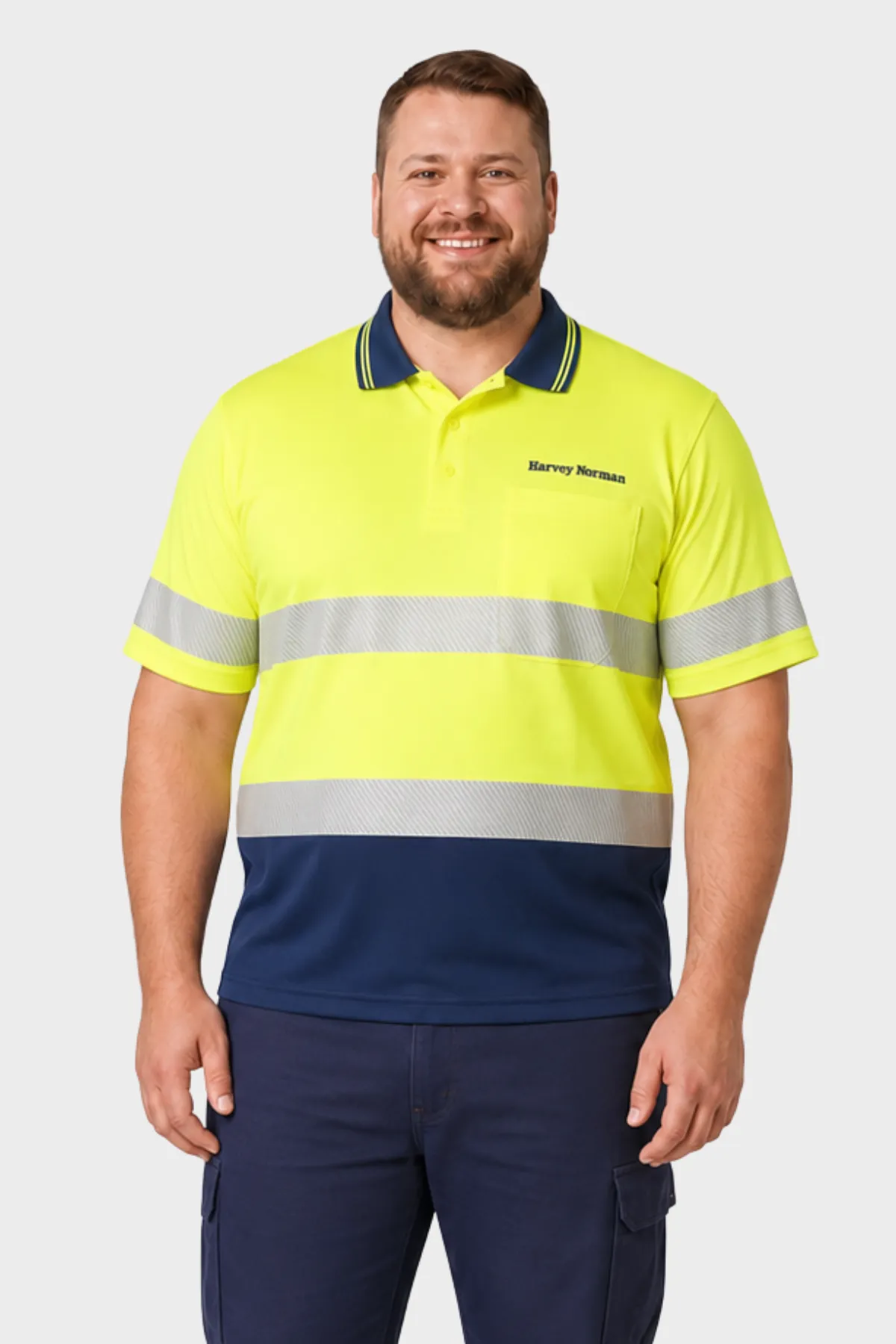 Man wearing a yellow and navy hi-vis polo with reflective tape and navy cargo trousers