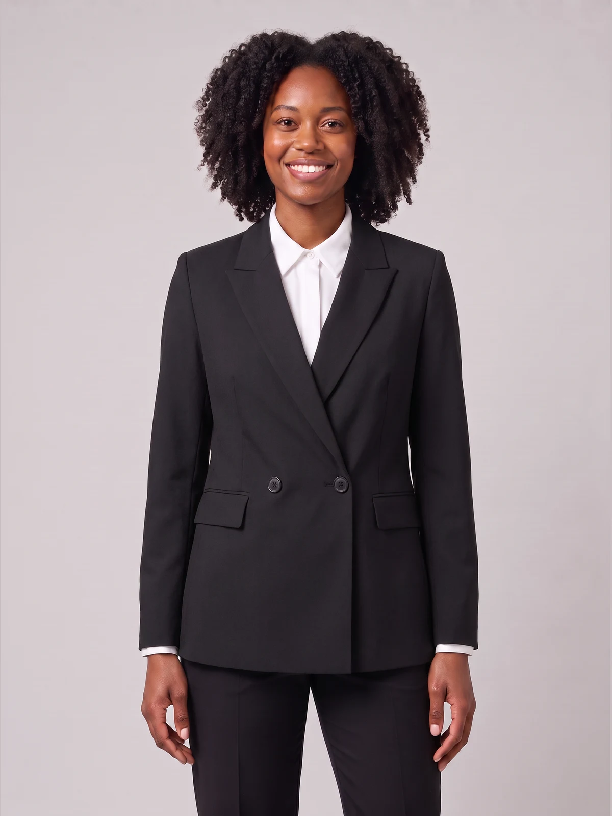 Woman wearing a black double-breasted suit jacket over a white shirt