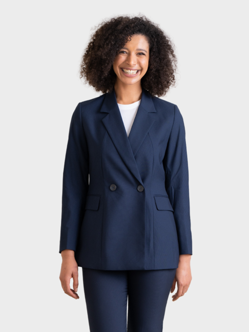 Woman wearing a navy double-breasted longline blazer over a white top