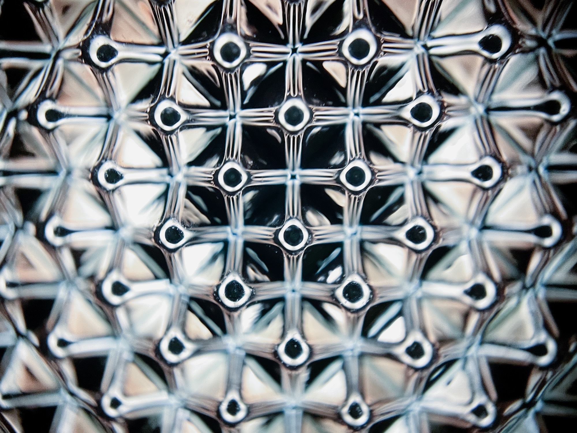 Close-up macro photograph of a metal surface with a diamond-pattern texture