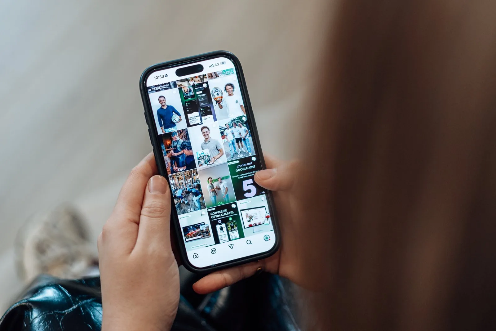 Telefoon in twee handen met de Instagram-feed van Online Actief op het scherm