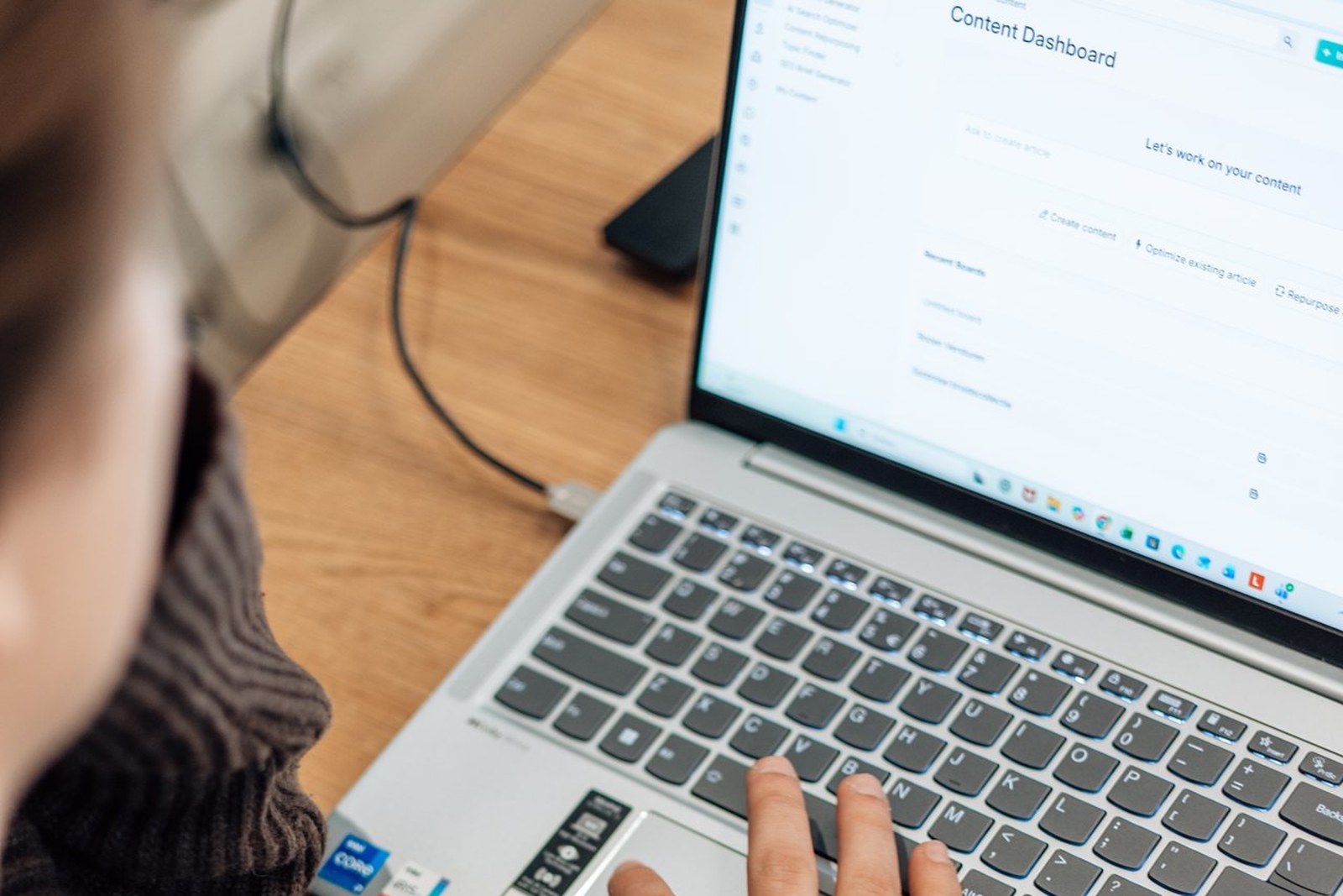 Over-de-schouder foto van persoon die werkt in een content dashboard op een laptop