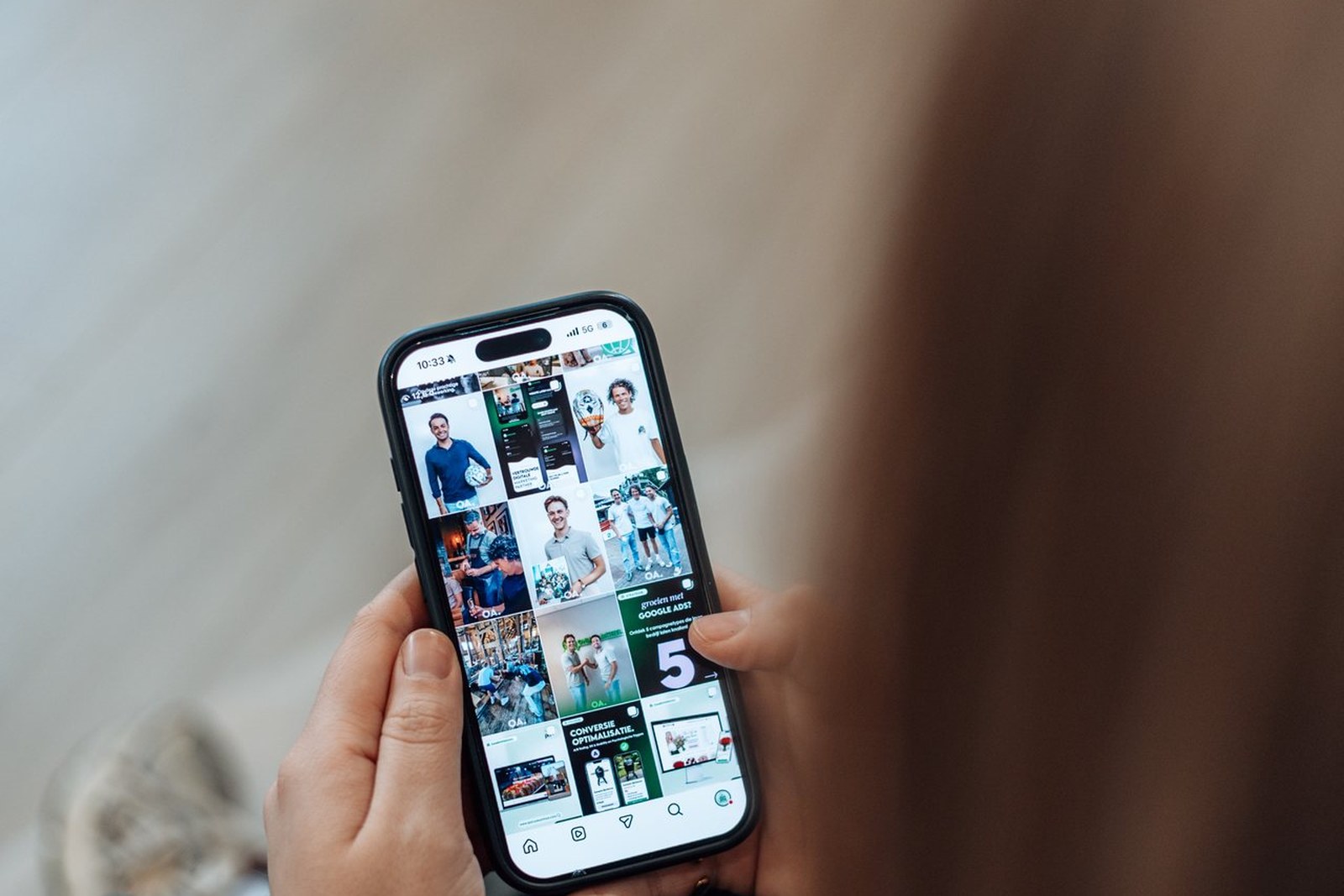 Handen houden smartphone vast met social media feed op het scherm