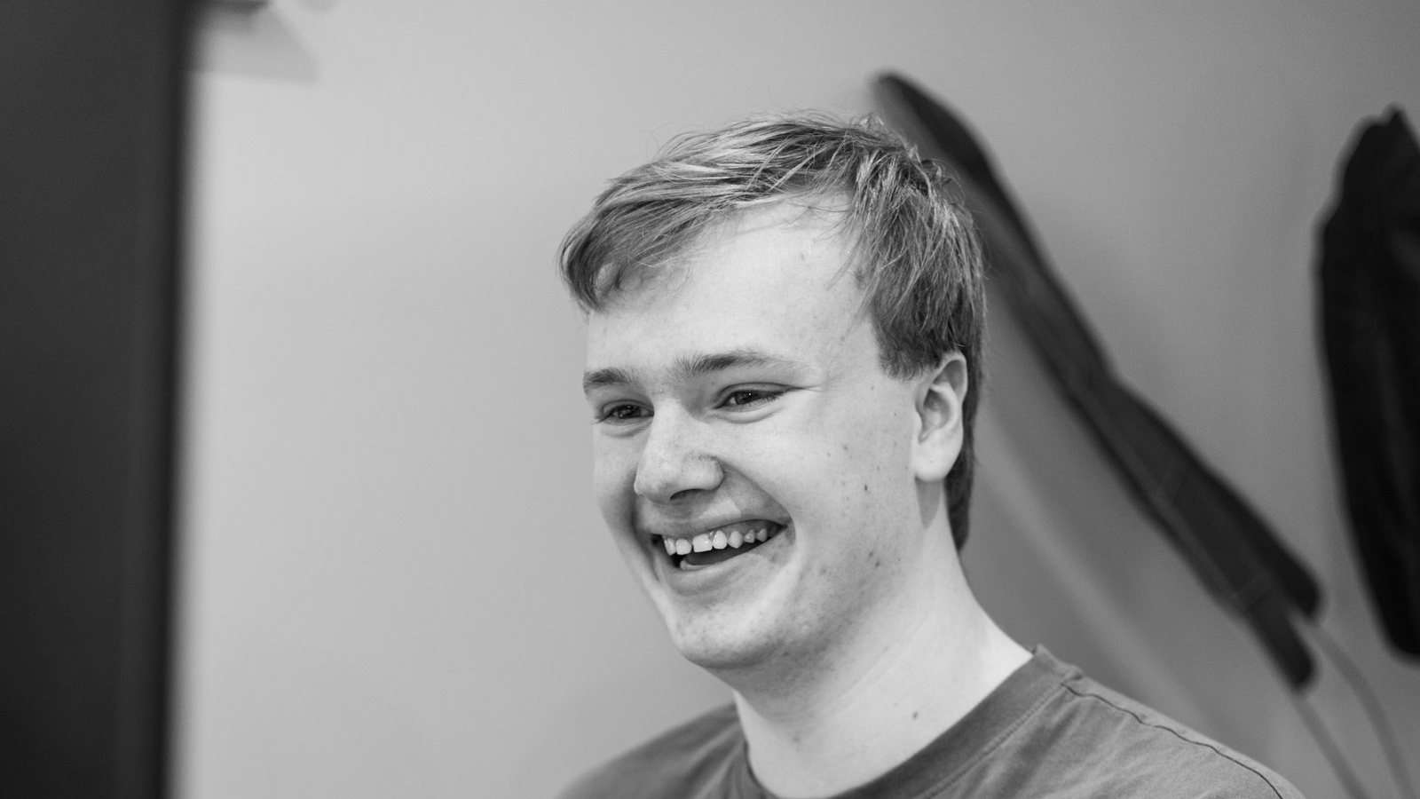Zwart-witfoto van een developer van Online Actief die lachend achter zijn beeldscherm werkt