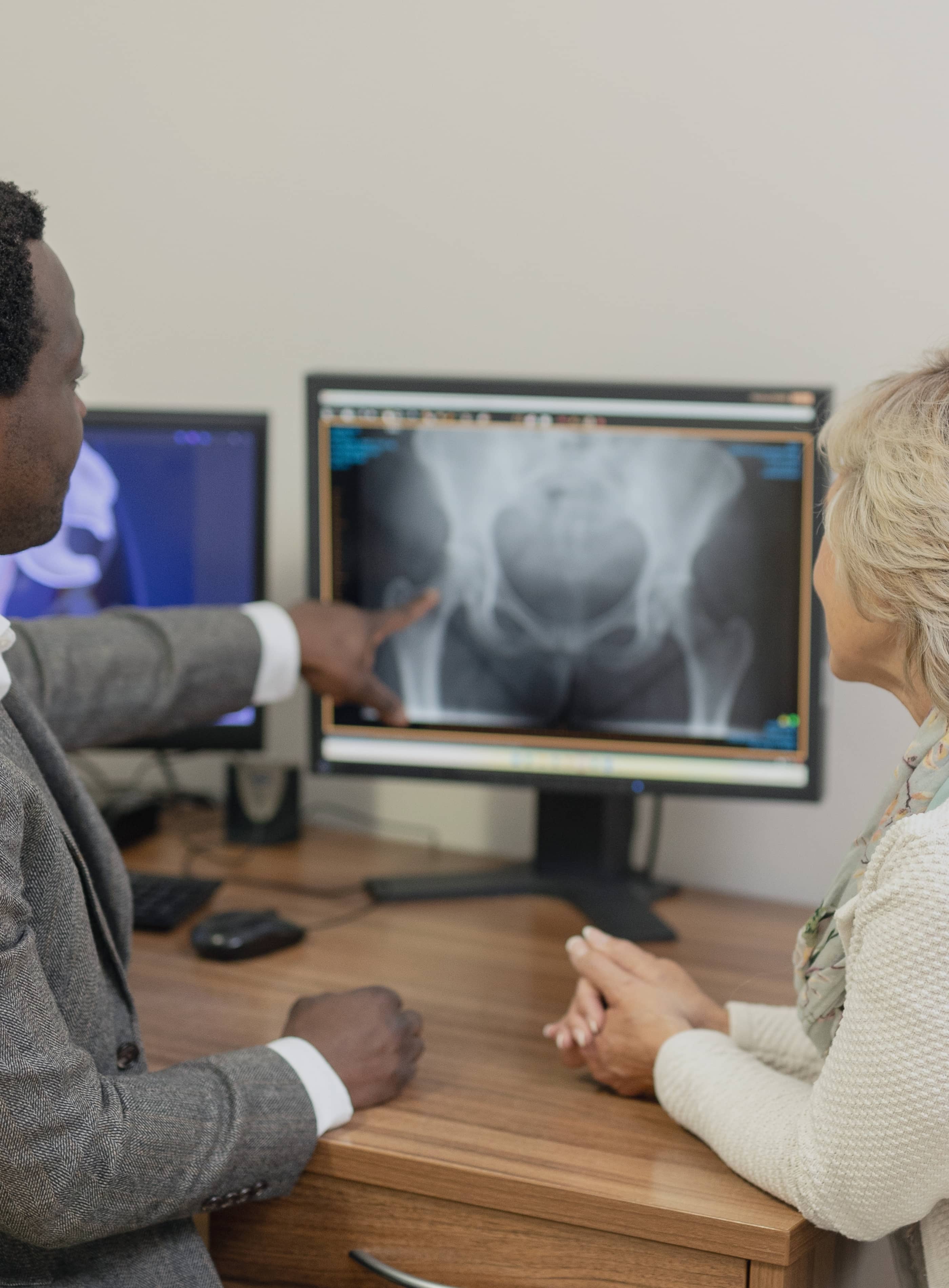 a close up image of two computer screens on Mr Oni's desk with a hip  x-ray and scan visible on the display,