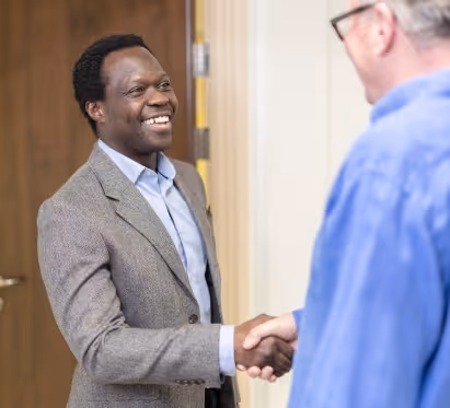 mr oni shaking hands with a male patient in a blue shirt