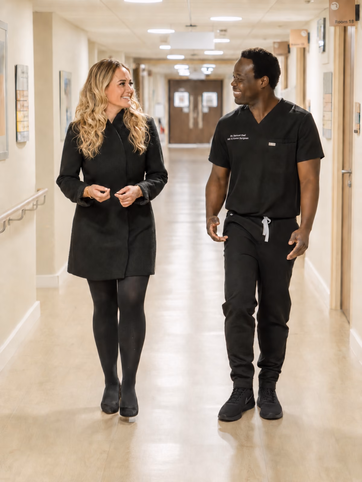 Mr Oni walking with his practice manager in a hospital corridor