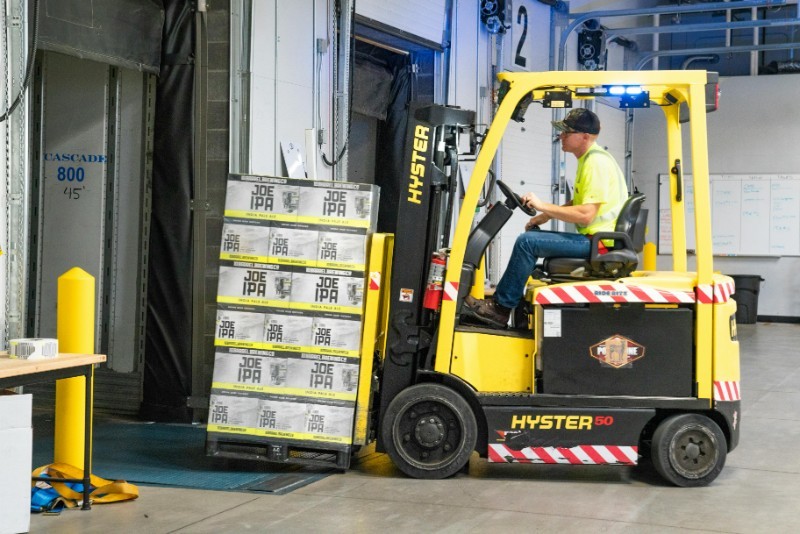 Forklift handling palletized inventory on a warehouse floor