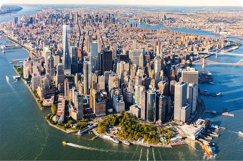 Aerial view of Lower Manhattan's skyscraper skyline surrounded by the Hudson and East Rivers.