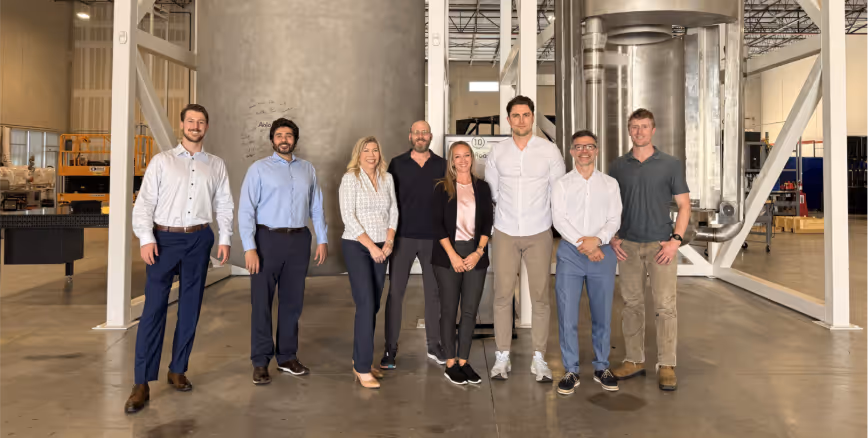 A group of people standing in a roomDescription automatically generated
