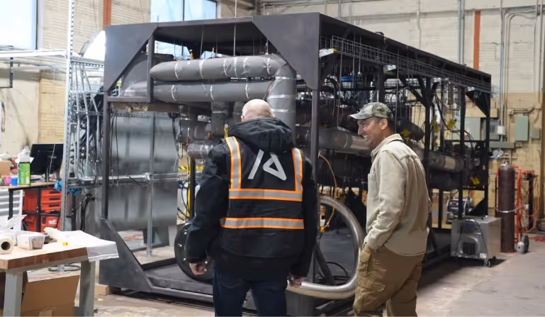Men standing next to a machineAI-generated content may be incorrect.