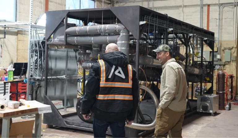 Men standing next to a machineAI-generated content may be incorrect.