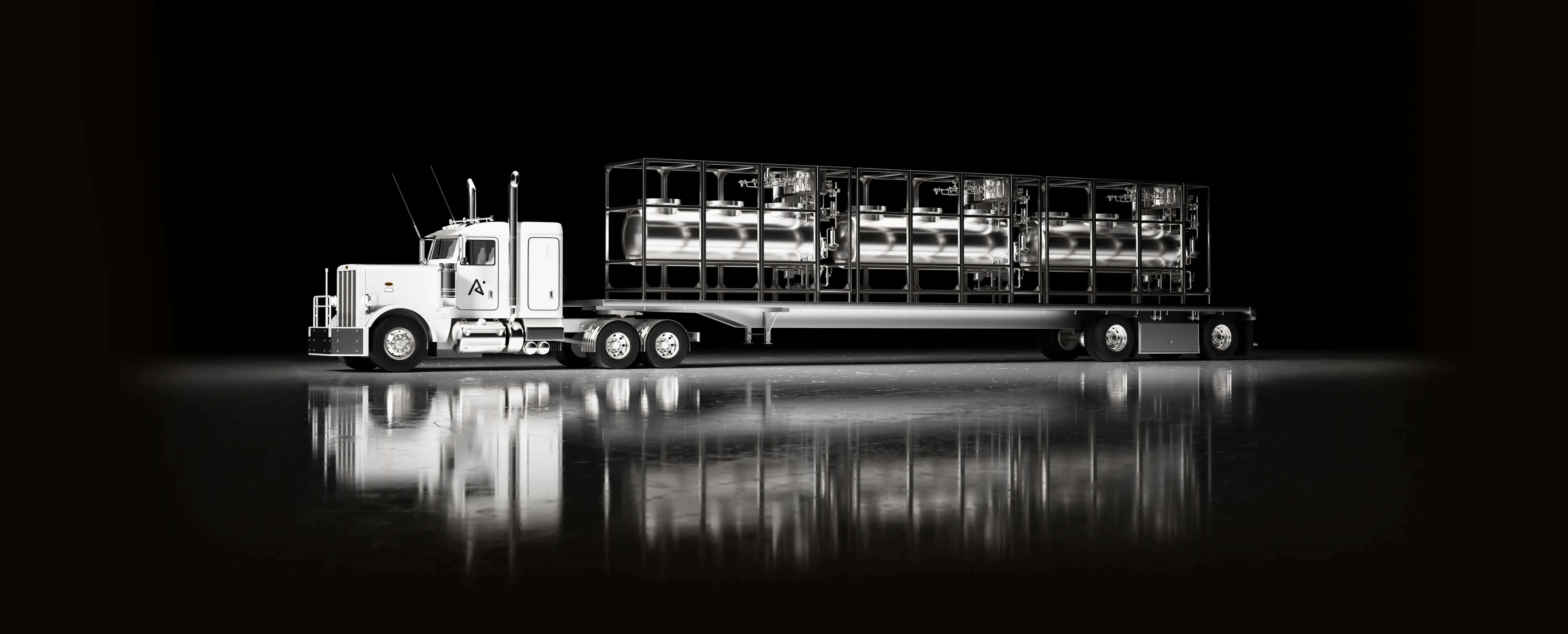 White semi truck with a flatbed trailer carrying three large cylindrical stainless steel tanks in black frame.
