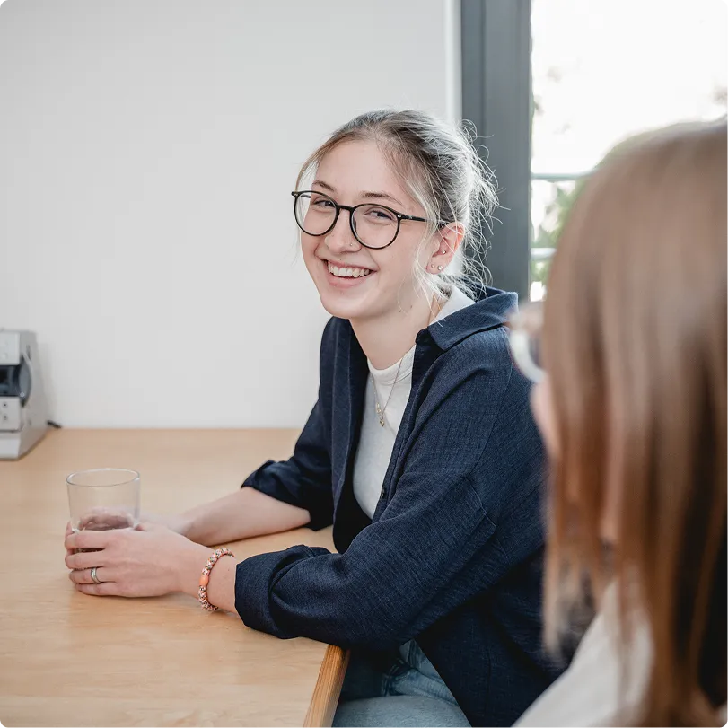 Junge Kollegin im Gespräch am Besprechungstisch